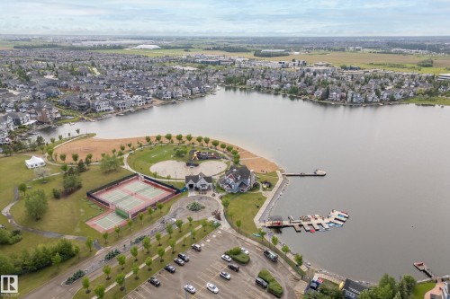 Expansive lakefront community featuring a private beach, multiple tennis courts, a clubhouse, a boat dock with moored vessels, and a surrounding residential development - 416 Sparling Crest Sw, Edmonton, AB - Outdoor With Body Of Water With View