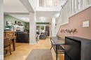 Open concept interior featuring light wood-finish flooring, a two-story foyer with a white balustrade staircase, and recessed lighting - 416 Sparling Crest Sw, Edmonton, AB  - Indoor 