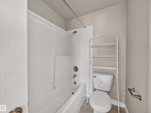 Bathroom featuring a white tub and shower surround, chrome fixtures, and neutral wall tones - #1208 9939 109 St Nw, Edmonton, AB - Indoor Photo Showing Bathroom