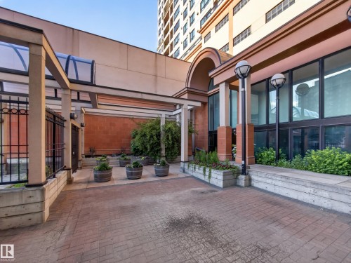 Paved brick courtyard with integrated planters featuring established greenery - #1208 9939 109 St Nw, Edmonton, AB - Outdoor