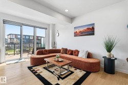 Living area with light wood-finish flooring, a contemporary ceiling, and recessed lighting - 