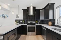 U-shaped kitchen featuring black cabinetry, light countertops, and a black subway tile backsplash - 