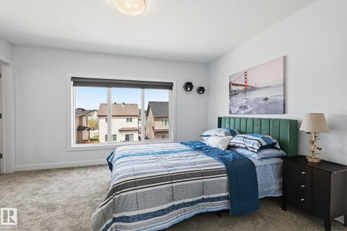 Bright room featuring a large window, plush gray carpeting, white painted walls, and a recessed ceiling light fixture - 8282 Chappelle Way Sw, Edmonton, AB - Indoor Photo Showing Bedroom