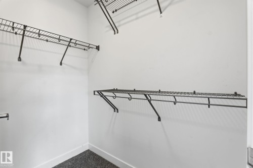 Walk-in closet featuring white walls, dark wire shelving, and dark textured carpeting - 8282 Chappelle Way Sw, Edmonton, AB - Indoor With Storage