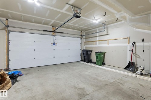 Spacious garage featuring a concrete floor, overhead lighting, and an automatic garage door opener - 8282 Chappelle Way Sw, Edmonton, AB - Indoor Photo Showing Garage
