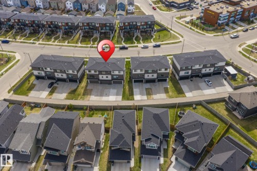 Modern townhome-style residences featuring contemporary dark exteriors, clean architectural lines, and individual driveways - 8282 Chappelle Way Sw, Edmonton, AB - Outdoor With View