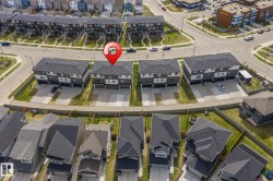Modern townhome-style residences featuring contemporary dark exteriors, clean architectural lines, and individual driveways - 