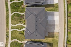 Gabled roofline with dark shingles, featuring multiple roof vents and a front-facing driveway - 