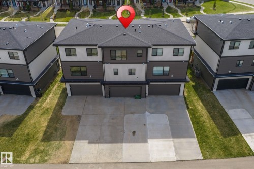 Contemporary multi-level townhome featuring a dark gray shingle roof, multi-tone siding, and an integrated garage - 8282 Chappelle Way Sw, Edmonton, AB - Outdoor With Facade