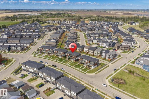 Aerial perspective of a developed residential area featuring a mix of detached homes and multi-story townhomes - 8282 Chappelle Way Sw, Edmonton, AB - Outdoor With View