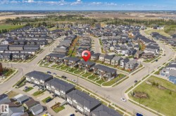 Aerial perspective of a developed residential area featuring a mix of detached homes and multi-story townhomes - 