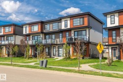 Modern multi-level exterior featuring varied siding materials and black-framed windows - 