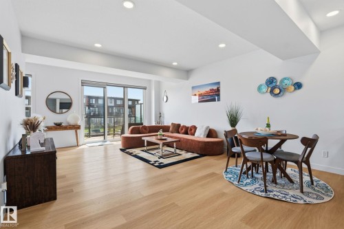 Open-concept living space featuring wood-finish flooring, recessed lighting, and a large sliding glass door - 8282 Chappelle Way Sw, Edmonton, AB - Indoor