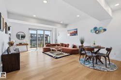 Open-concept living space featuring wood-finish flooring, recessed lighting, and a large sliding glass door - 