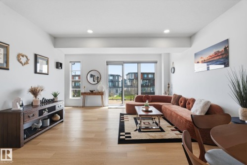 Spacious interior featuring light wood-finish flooring, recessed lighting, expansive glass sliding doors, and large windows providing abundant natural light - 8282 Chappelle Way Sw, Edmonton, AB - Indoor Photo Showing Living Room
