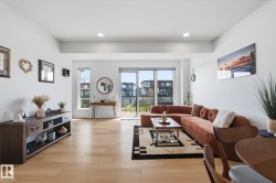 Spacious interior featuring light wood-finish flooring, recessed lighting, expansive glass sliding doors, and large windows providing abundant natural light - 