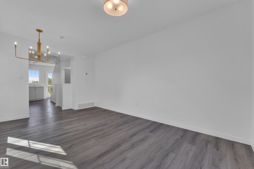 Spacious interior with neutral white walls and wood-finish flooring - #64 17832 78 St Nw Nw, Edmonton, AB - Indoor Photo Showing Other Room