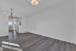 Spacious interior with neutral white walls and wood-finish flooring - 