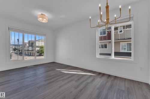 Spacious room featuring light gray wood-finish flooring and white walls - #64 17832 78 St Nw Nw, Edmonton, AB - Indoor Photo Showing Other Room
