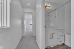 Bright hallway featuring light gray carpeting, recessed lighting, and a window with white trim - 