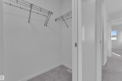 Recessed closet space with wire shelving, light gray carpeting, and white baseboards - 