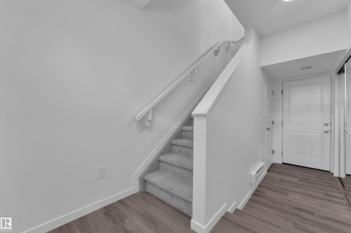 Staircase featuring carpeted treads and a painted railing - #64 17832 78 St Nw Nw, Edmonton, AB - Indoor Photo Showing Other Room