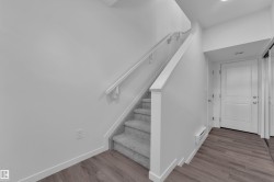 Staircase featuring carpeted treads and a painted railing - 