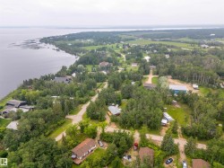 Expansive waterfront property featuring a treed landscape, multiple residential structures, and direct shoreline access - 