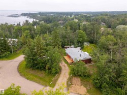Single-story property with a wood-sided exterior, a light gray shingle roof, and a prominent wooden deck - 