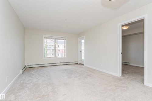 Light-colored wall-to-wall carpeting throughout - #322 5816 Mullen Pl Nw, Edmonton, AB - Indoor Photo Showing Other Room
