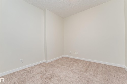 Neutral-toned carpeting paired with light-colored walls - #322 5816 Mullen Pl Nw, Edmonton, AB - Indoor Photo Showing Other Room
