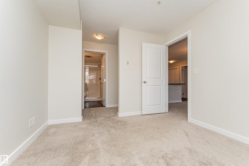 Carpeted room with light-colored walls and baseboards - #322 5816 Mullen Pl Nw, Edmonton, AB - Indoor Photo Showing Other Room