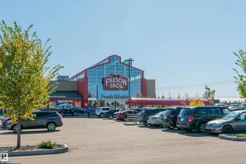 Retail building featuring a distinctive red facade and extensive glass frontage - #322 5816 Mullen Pl Nw, Edmonton, AB - Outdoor