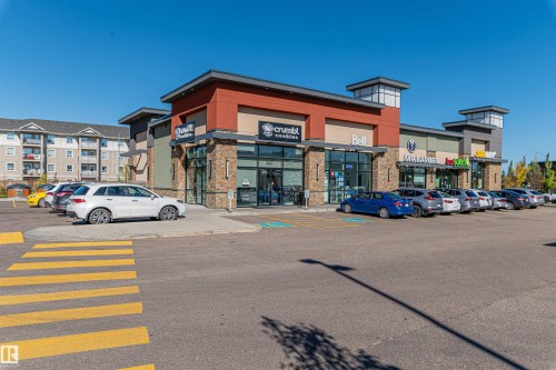 Modern commercial complex featuring diverse retail storefronts - #322 5816 Mullen Pl Nw, Edmonton, AB - Outdoor