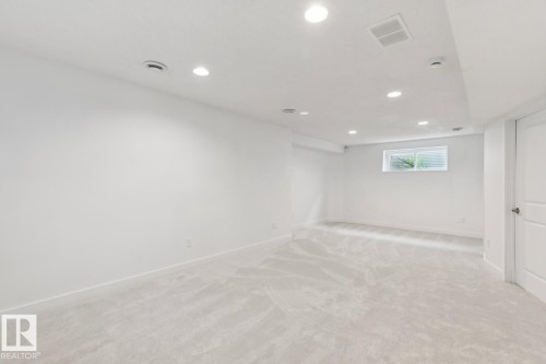 Spacious room featuring light-toned carpeting, recessed lighting, and a white paneled door - 64 Foxboro Link, Sherwood Park, AB - Indoor