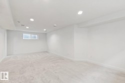 Spacious room featuring light-colored carpeting, white painted walls, and recessed lighting - 