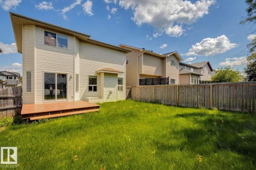 Spacious rear yard featuring a large wooden deck, sliding glass patio doors, and a full privacy fence - 64 Foxboro Link, Sherwood Park, AB - Outdoor