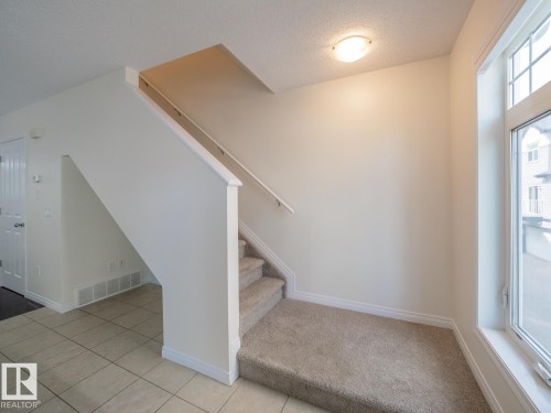 Carpeted staircase with white balustrade and trim - #66 465 Hemingway Rd Nw, Edmonton, AB - Indoor