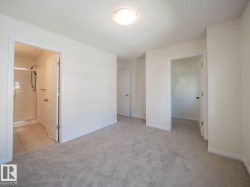 Spacious room featuring neutral carpet flooring, recessed lighting, and access to a full bathroom with a stand-up shower - 