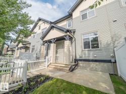 Multi-level townhome exterior featuring light gray siding and contrasting trim - 