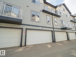 Multi-level residential building featuring light grey siding with dark trim accents - 