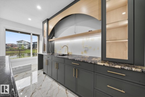 Custom cabinetry with gold hardware, a brass faucet, and stone countertops - 11 Harley Way, Spruce Grove, AB - Indoor Photo Showing Other Room