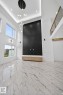 High-ceiling living area featuring large format marble-look floor tiling, a dramatic dark accent wall, and a contemporary multi-pendant chandelier - 11 Harley Way, Spruce Grove, AB  - Indoor Photo Showing Other Room 