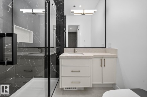 Modern bathroom featuring a glass-enclosed shower with dark-veined tile surround and a recessed niche - 11 Harley Way, Spruce Grove, AB - Indoor Photo Showing Bathroom