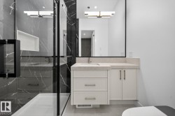 Modern bathroom featuring a glass-enclosed shower with dark-veined tile surround and a recessed niche - 