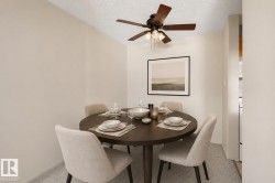 Dining area featuring a ceiling fan with light fixture and neutral-toned walls - 