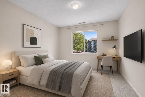 Bright room with a large window, light-toned walls, and neutral carpeting - #224 16303 95 St Nw, Edmonton, AB - Indoor Photo Showing Bedroom