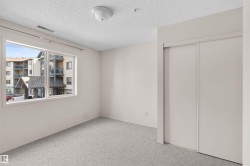 Bright room featuring light-toned carpeting, a large window, and a white ceiling-mounted light fixture - 