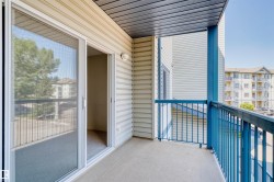 Private balcony featuring a concrete floor, light beige siding, and blue metal railings - 