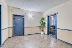 Entryway featuring patterned tile flooring, textured two-tone walls, and a glass-paneled door with blue trim - 